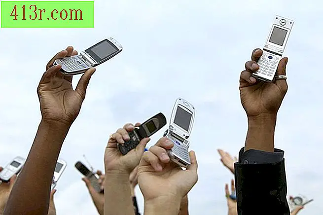Lidé drží mobilní telefony ve vzduchu.